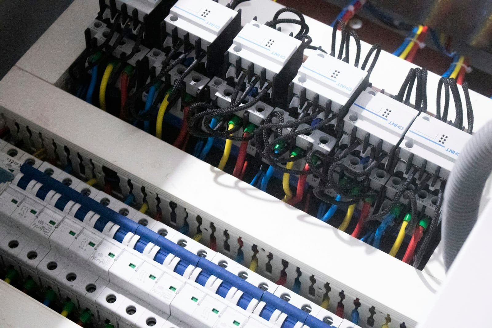 Quadro elétrico com disjuntores e fios coloridos