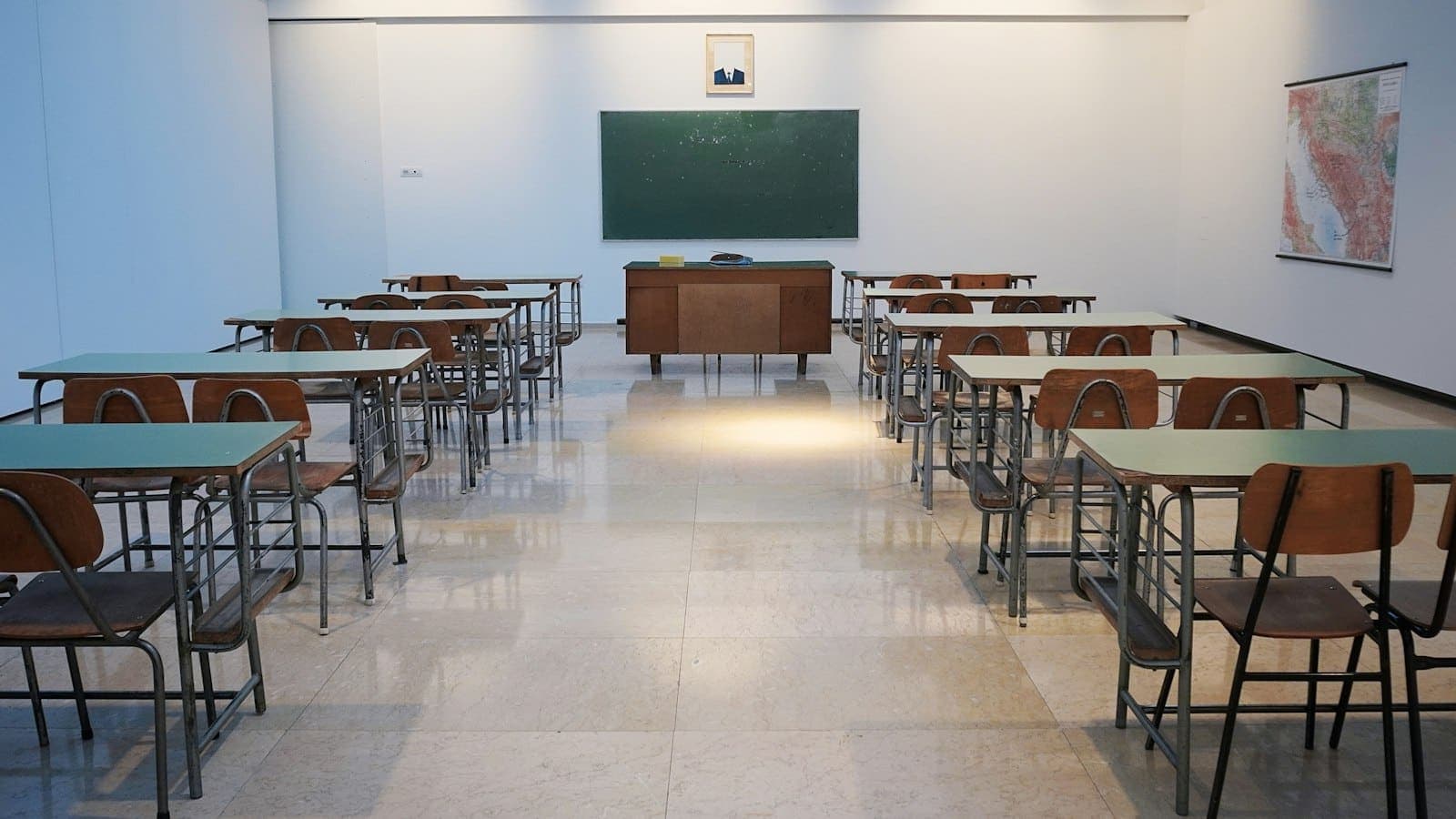 Sala de aula vazia com carteiras e quadro-negro