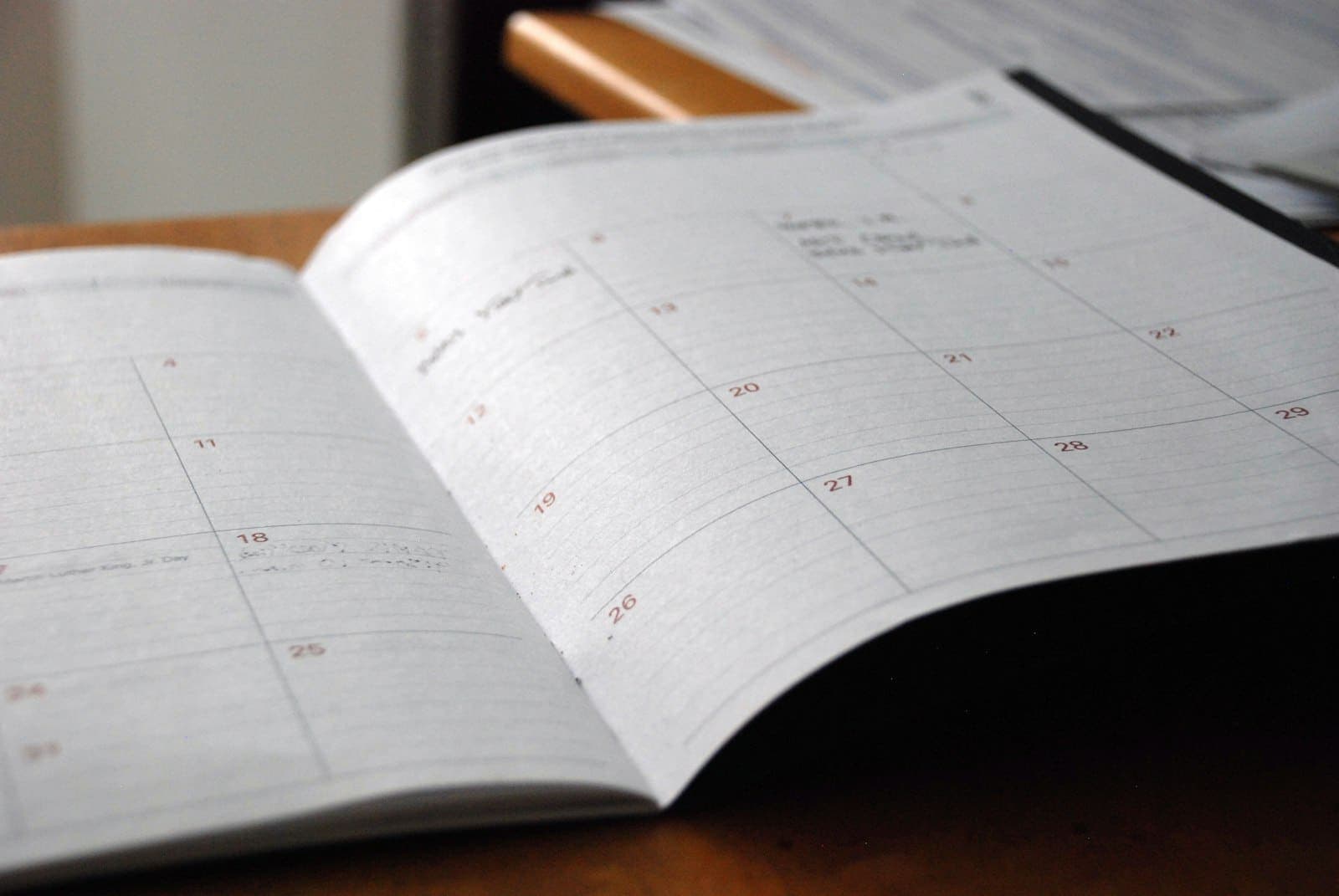 Agenda mensal aberta sobre uma mesa de madeira